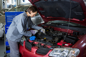 female mechanic checking oil level car engine